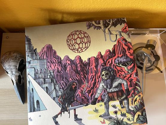 Die Plattenhülle liegt auf der Abdeckhaube des Plattenspielers. Auf dem Cover sieht man eine psychedelisch bunte Grafik, die im Vordergrund zwei Aliens zeigt, die sich am Rand einer Schlucht zum Zweikampf bereit gegenüberstehen, bewaffnet mit Schwert und Axt. Im Hintergrund befindet sich links eine in Blautönen gehaltene Festung, zu der eine Brücke führt, rechts davon in Violett- und Rottönen zerklüftete Felsen. Am gelblichbraunen Himmel schwebt eine Kugel mit filigraner Wabenstruktur.