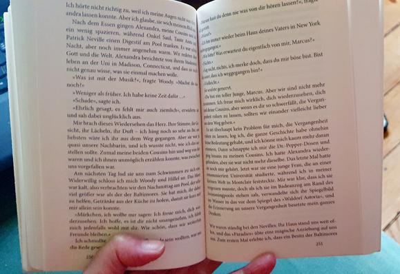 Eine Hand hält ein aufgeschlagenes Buch