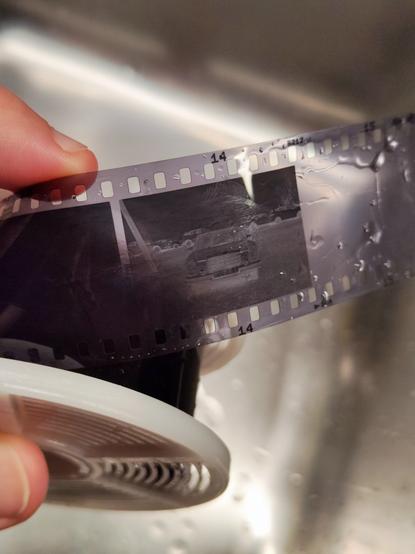 A strip of film still on the development reel and wet.