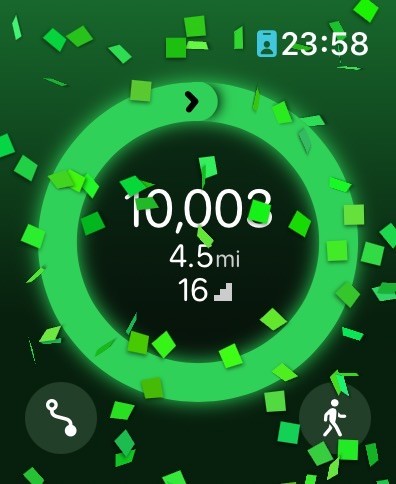 Pedometer++ celebration screen on the Apple Watch showing 10,003 steps at 23:58.