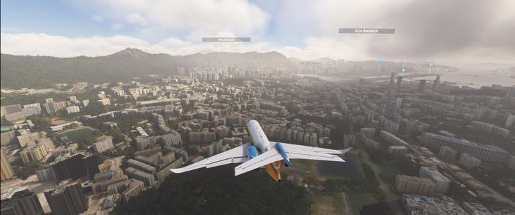 A Cessna Citation Longitude flies in low over slightly hazy Hong Kong to land at Kai Tak runway 13. Checkerboard hill is just ahead of the plane and the runway is visible in the harbour.