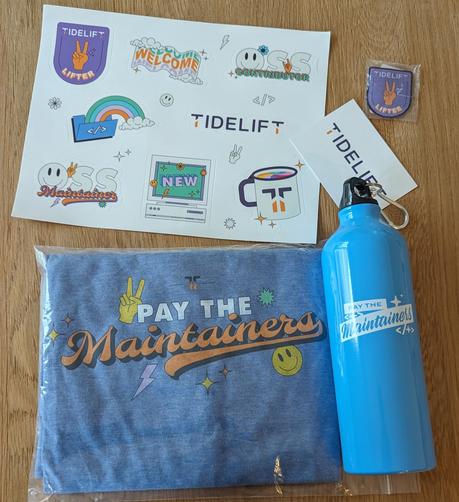 A t-shirt with "pay the maintainers", some cute emoji and the Tidelift logo, a "pay the maintainers" water bottle, a "Tidelift lifter" patch to sew onto i.e. a jacket, and a book of various Tidelift stickers, which all look really great!