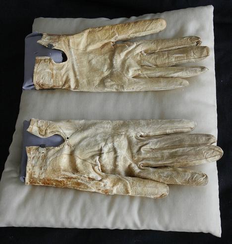 A pair of white gloves stained with blood