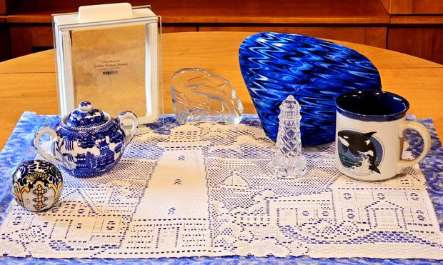 A tea tableau of an ocean scene with a whale, dolphins, and a lighthouse. The tea is Golden Heaven Yunnan from English Tea Store.