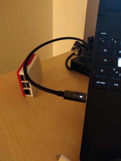 Raspberry Pi 4 in a case, supporting the usb-c cable connected to the laptop