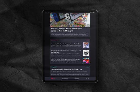 feeeed-App mit Newsfeed im Dunkel- und Porträtmodus auf einem iPad Pro vor dunkelgrauem Hintergrund.