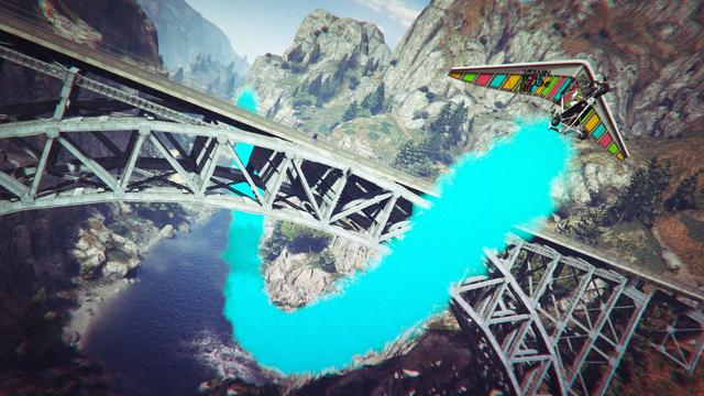 A screenshot I took in the video game GTA Online using the Rockstar Editor. It shows my character passing below the train bridge at Cassidy Creek using a Nagasaki Ultralight glider with turquoise smoke countermeasure activated.