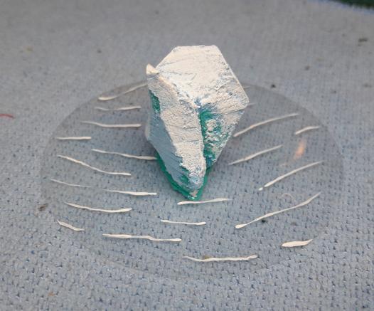 Icerberg for wargaming made of carved foam glued to a clear circle of plastic with painted waves.