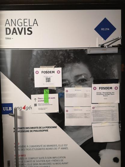 A selection of printouts from FOSDEM taped to a wall celebrating Angela Davis