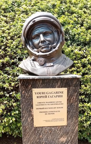 Bronza busto de Yuri Gagarin en sia spaca vestaĵo, kun bildo-tekstoj en rusa kirunda kaj franca