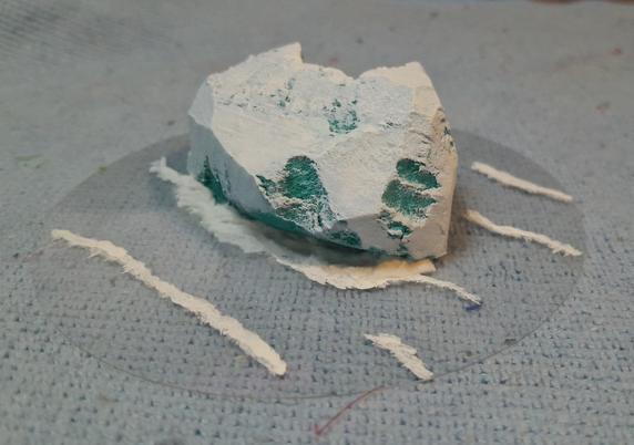 an iceberg for wargaming, carved and painted foam on top of clear plastic with painted waves