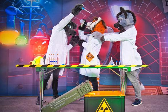 Three fursuiters in labcoats posing with fake lab equipment.