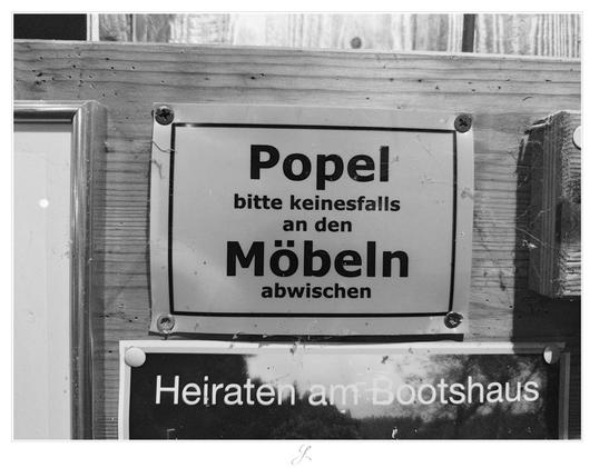 Black and white shot of a typical yellow plastic sign screwed to a wooden wall. The German wording reads translated to English as "Please by no means wipe off boogers on the furniture!"

AI disclaimer: Using my work, its meta data, written or derived description to create media with or train AI based systems is prohibited.