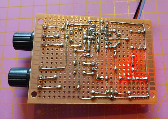 back side of the board showing the soldering. the LED is shining through