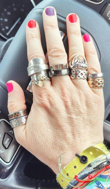 My right hand. The nails are painted; thumb and little finger - shiny pink, index and third finger - matt bright red, middle finger - matt aubergine.
Rings: 
Thumb - a black carbon fibre patterned ring and a sliver coloured ring with moveable cogs on it 
Index finger - a ring made from a flattened silver tea spoon and a thin brass coloured ring with square ends.
Middle finger - a silver ring that says "FUCK" and a plain looking black ring 
Third finger - a silver Celtic band and a silver set of vampire teeth
Little finger - 4 rings on this one. Two wedding rings from my first marriage welded together, a thin Tri-gold twist and a cheap silver ring that makes sure the others don't come off.