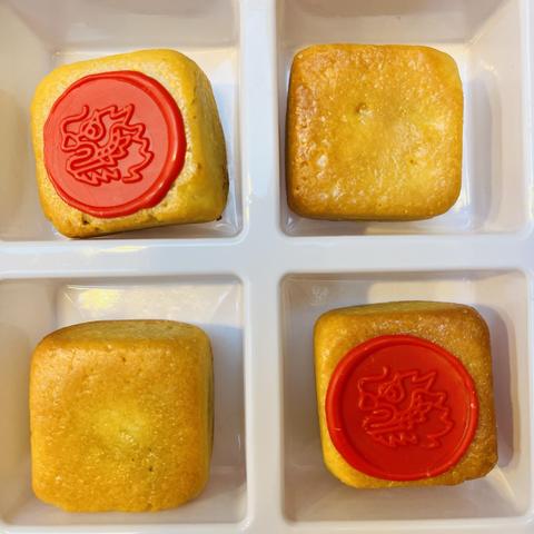 Four pineapple pastries, two with red icing stamped on top