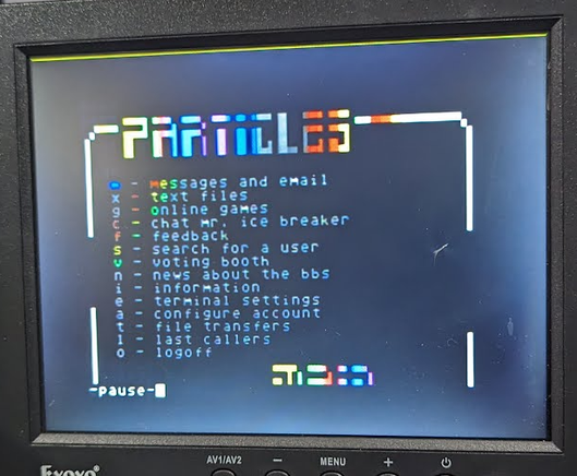 An small LCD with a backlighting issues connected to the ParticlesBBS . Pictured is the main menu of the BBS.