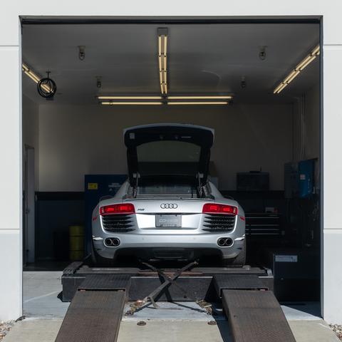 Rear of a silver sports car on a dyno setup.