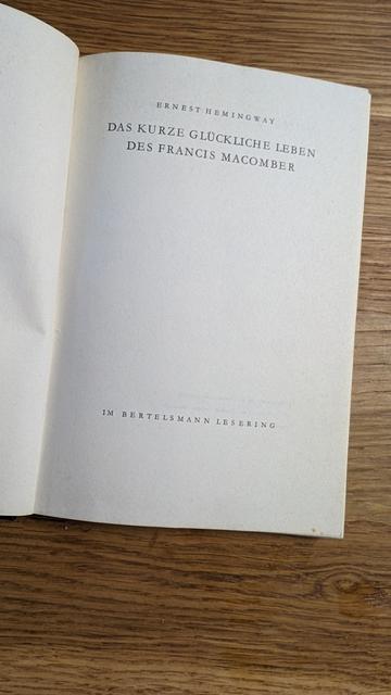 Ein aufgeschlagenes Buch auf einem Holztisch.