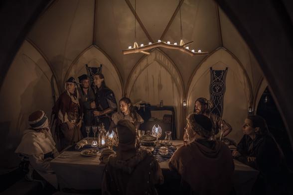 Elvish tent at night. Elves and guests are gathered around a large table.