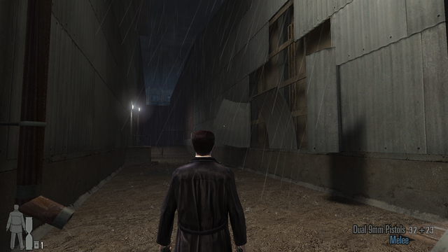Screenshot from Max Payne 2. Max Payne is standing in an alleyway between two industrial buildings with corrugated iron walls. A section of the wall on the right is peeled / fallen off exposing the wooden framing underneath.