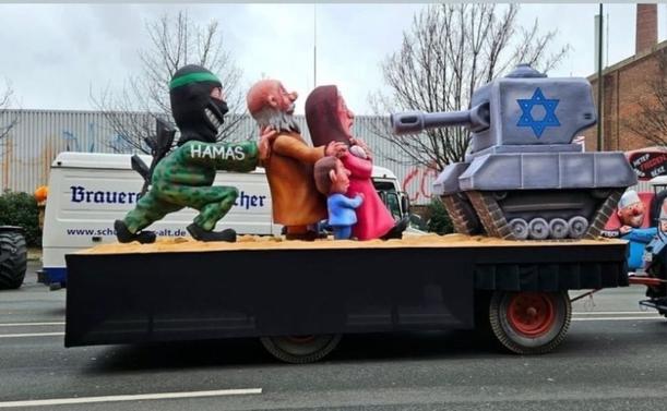 A float at yesterday's Carnevale in Germany depicting a Hamas militant putting innocent women and children between him and an IOF tank, implying that its OK to kill women and children if they are in the way of Hamas.