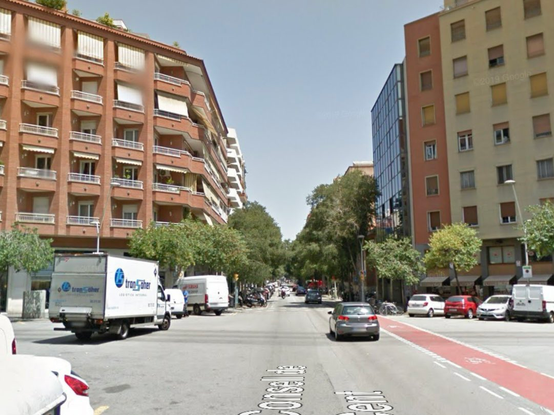 Google street view of an intersection in Barcelona from 2016. It is wide and full of cars and delivery vans.
