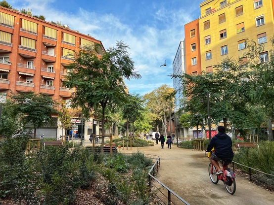 Same intersection photographed by me in November 2023. It is lush and planted and there is a guy riding a bike.