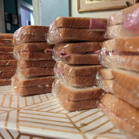 A stack of sandwiches wrapped in plastic wrap.