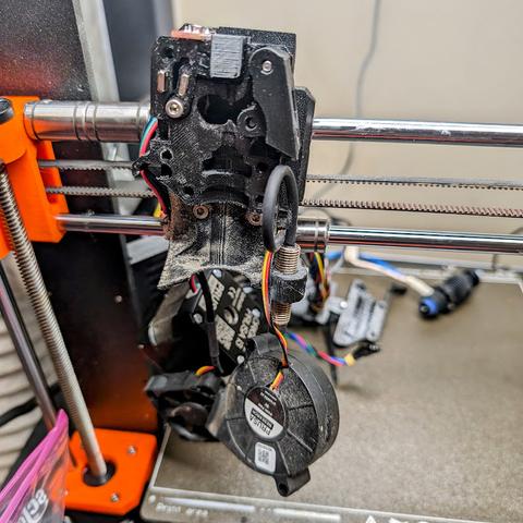 A hastily disassembled and very dirty extruder assembly from a Prusa MK3S+.