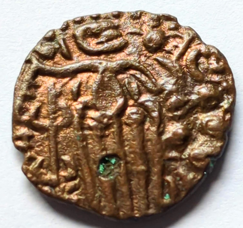 Standing king with lotus on the left a group of spheres on right, surmounted by crescent.