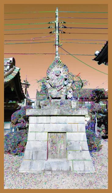 A sculpture of a Buddha at a temple in Japan. It is made of stone and sits on a head-high pedestal. There are pagoda-like roofs poking in on either side and there is an electrician pole centered on the head. I've changed the color spectrum to make the sky golden brown and I've added slight colorful accents around the contrast lines in the image.