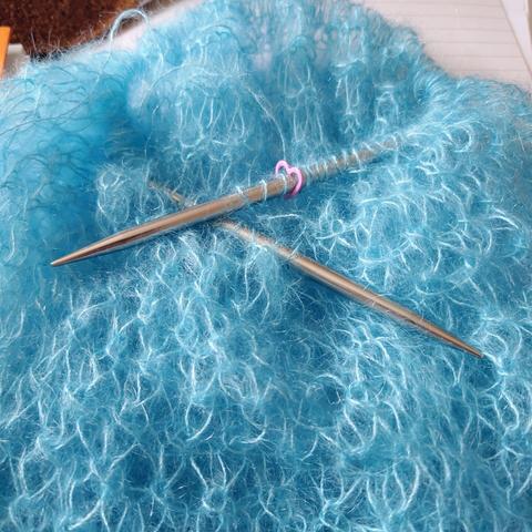 A pale blue cowl with yarn with mohair and silk.