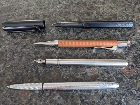 Open display of:

LAMY AL-star black EMR Stylus with a felt tip

Faber Castell pencil

Kaweco Lilliput fountain pen 

Fisher Space Pen