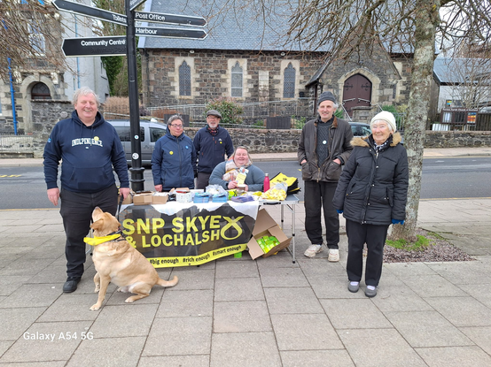 Street stall at Portree on Skye with activists, and a guide dog, surrounding it