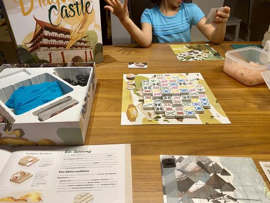 Dragon Castle mit ausgelegten Bausteinen und vorbereiteten Spielertableaus…