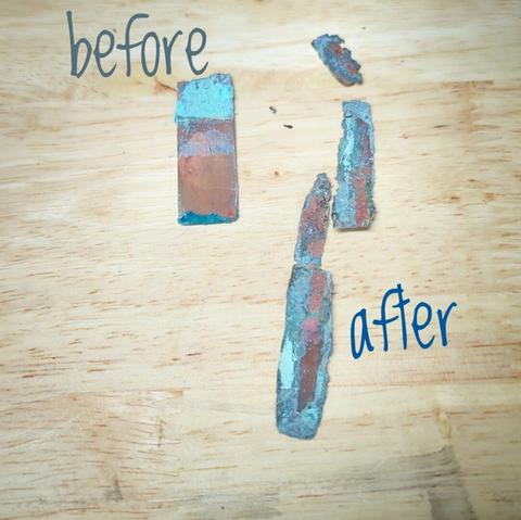 A wood background, the table. On top are 4 pieces of metal. On the left a 2 inch by 1 inch piece of copper that is slightly corroded. On the right there are 3 smaller, jagged strips of copper that are heavily corroded.