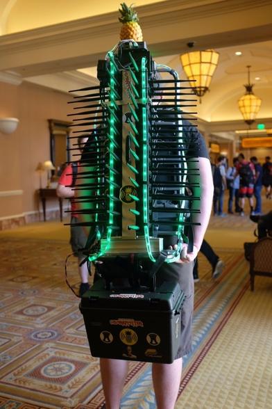 A person carring a stack of 13 WiFi Pineapple Routers wirh 6 Antennaa each in a custom back-mounted plate with a huge battery pack strapped below and a faomke pineapple mounted on top.

This "WiFi cactus" also has some green LED tubes lined around to emphasize the "cactus" shape...