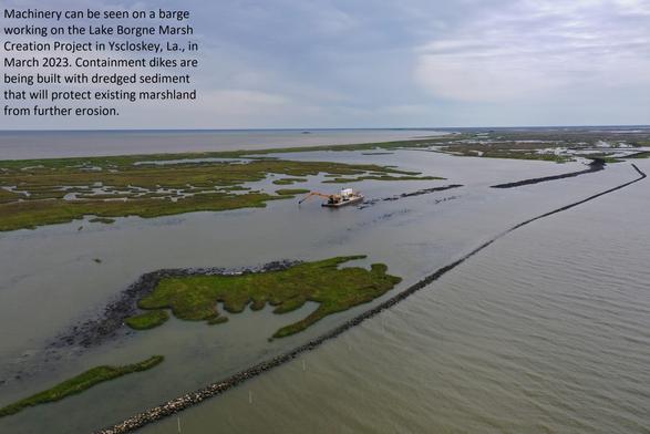 photo - Machinery can be seen on a barge working on the Lake Borgne Marsh Creation Project in Yscloskey, La., in March 2023. Containment dikes are being built with dredged sediment that will protect existing marshland from further erosion.