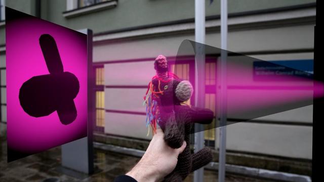 Das Bild zeigt Max Horn, das Strickeinhorn, in einer kreativen Darstellung vor dem Röntgen-Labor in Würzburg. Das Einhorn wird von einer Hand hochgehalten, während im Hintergrund die Fassade des Labors zu sehen ist. Digital in die Szene eingefügt ist ein leuchtender pinker „Röntgenstrahl“, der vom Kopf des Einhorns ausgeht und auf einen ebenfalls digital hinzugefügten „Röntgendetektor“ trifft. Auf diesem Detektor ist die Silhouette von Max Horns Kopf und Horn als Schattenwurf zu erkennen, was die Verbindung zur Röntgentechnik spielerisch visualisiert. Das Bild ist eine humorvolle Anspielung auf die wissenschaftlichen Aktivitäten, bei welchen das Strickeinhorn seinen Menschen begleitet – und verbindet die Welt der Wissenschaft mit der Phantasie.

Im verlinkten Video wird Max Horn von Hand gedreht, das Schattenbild folgt ihm.