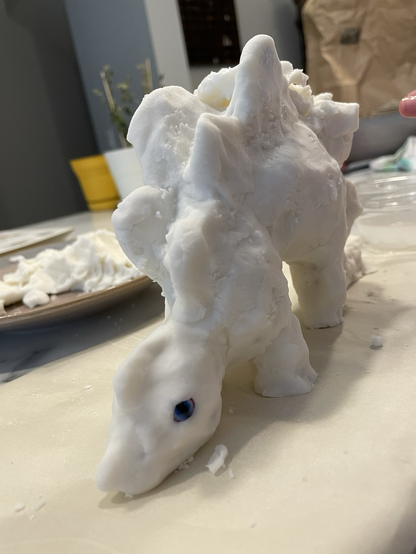 The wooden stegosaurus skelly is now encased in white modelling clay. It has purple-turquoise eyes set in its face, and is generally lumpy and wobbly. As it should be.