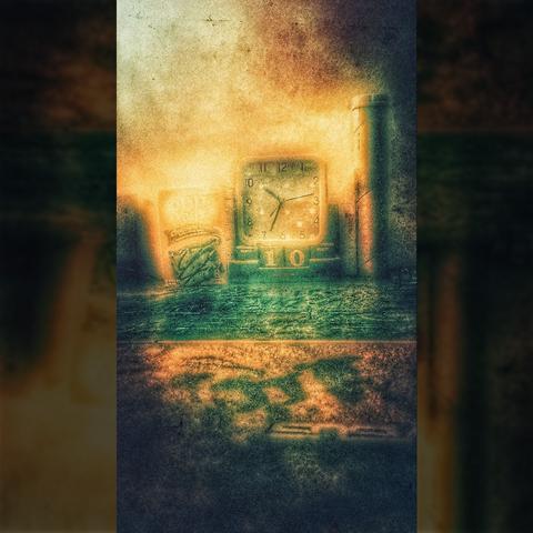 A clock placed on top of a novelty wooden calendar composed of blocks for months and numbers and a tray to hold the blocks. Other desk items add to the lowbrow sci-fi composition. Overlayed and overproduced with enough filters to create an aesthetic that the first person to see it referred to as "so 2010"