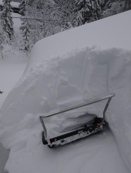 Snøskuffe som står inn under en meter med snø på hyttetak