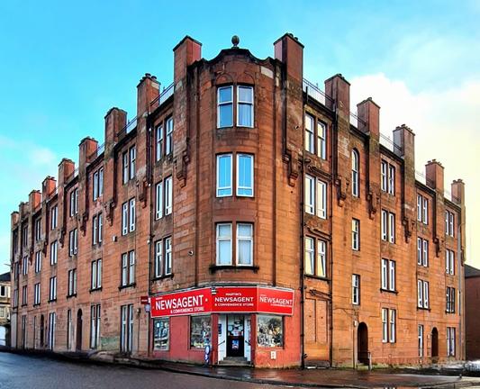 A red sandatone tenement with the appearance of a fortress.