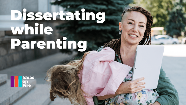 Parent holds a young child and a tablet, text reads: Dissertating while parenting