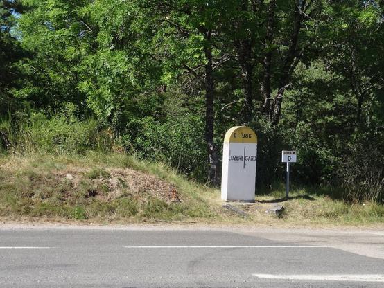 Sous une garrigue, une borne établit les limites du Gard et de la Lozère