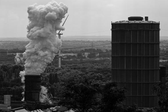 Blick vom Bottroper Tetraeder: vorn Kühlurm und Gasometer. Eine Dampfwolke steigt auf, dahinter halb verdeckt ein Windrad