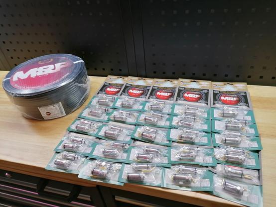 A spool of 100m Ultraflex 7 and 50 EVO PL-connectors on a workbench.