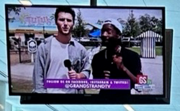 1. Photo of TV displaying (@)GRANDSTRANDTV