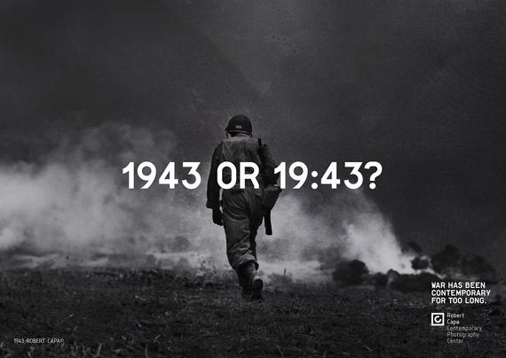 A black and white photo with centered text that reads "1943 or 19:43?". The photo shows a soldier with a shouldered rifle walking away on a smoking field.